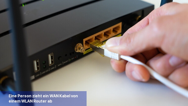 Eine Person zieht ein WAN-Kabel von einem WLAN-Router ab